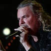 Fernando Olvera, vocalista de Maná, con un micrófono sobre las manos.