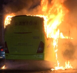Se observa un camión color verde incendiándose; es de noche.