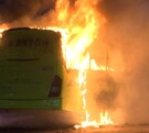 Se observa un camión color verde incendiándose; es de noche.