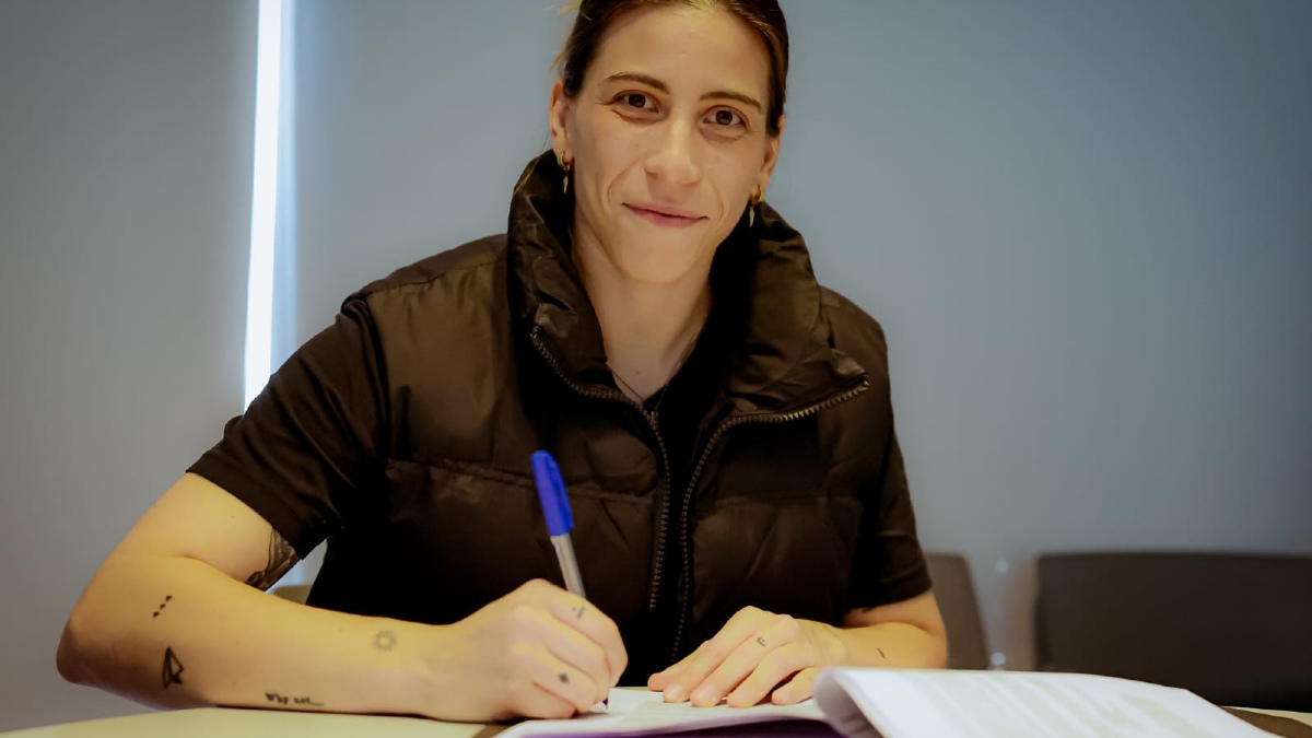 Renata escribiendo sobre una libreta sentada en un escritorio