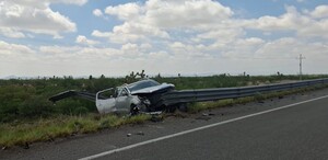 Se observa una camioneta color gris chocada contra barra metálica.