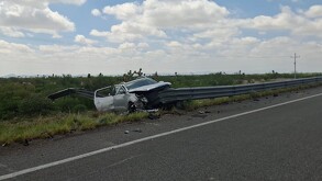 Se observa una camioneta color gris chocada contra barra metálica.