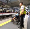 Personal de seguridad de Siteur con una persona en silla de ruedas en una estación del Tren Ligero en Guadalajara