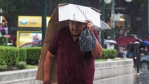 Hombre cubriéndose de la lluvia en CdMx