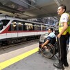 Personal de seguridad de Siteur con una persona en silla de ruedas en una estación del Tren Ligero en Guadalajara