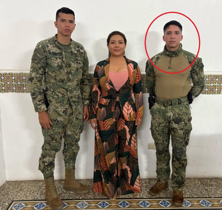 Mujer posa para una fotografía junto con dos hombres con traje militar.