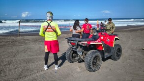 Cuatrimoto y elementos de Protección Civil y Bomberos de Colima con un militar del Ejército resguardando un área acordonada a la orilla de una playa