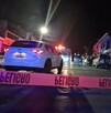Se observa una patrulla y uan cintilla roja de precaución; es de noche.
