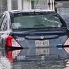 Automóvil Nissan Versa color azul atrapado en medio de una inundación en calles de Zapopan