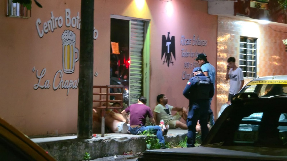 Policía resguardando el cuerpo de un hombre afuera de un botanero.