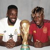 Iñaki Williams y Nico Williams con las playeras de sus selecciones y la Copa del Mundo.