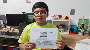 un joven con lentes sostiene un reconocimiento
