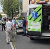 Ambulancia y paramédicos de la Cruz Verde en el sitio donde un policía vial fue atropellado por un auto en Guadalajara con personas y oficiales alrededor