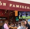 Restaurante con partido de México vs Ghana en la pantalla y hombres conviviendo