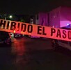 Se observa una cinta amarilla de precaución, es de noche y hay una patrulla.