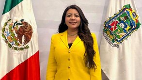 Mujer con un vestido amarillo posando para una fotografía.