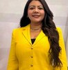 Mujer con un vestido amarillo posando para una fotografía.