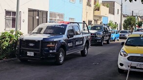 Patrullas de la Policía Municipal de Guadalajara estacionadas al exterior de unas casas con autos y un taxi alrededor