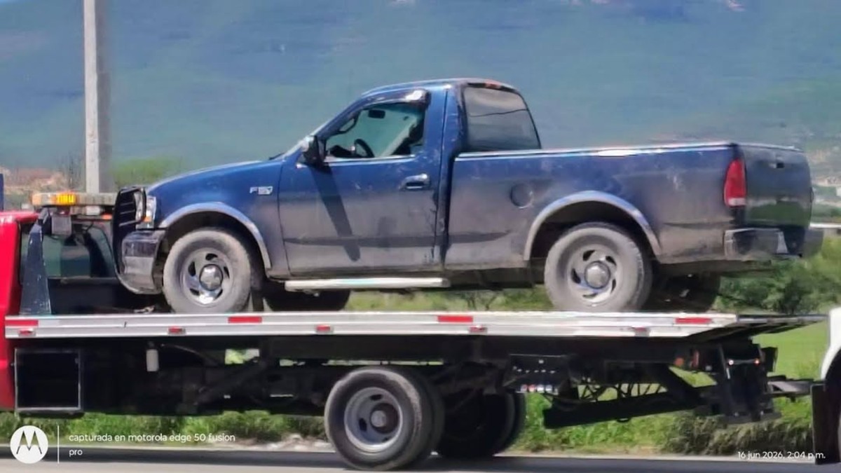 Camioneta color azul montado en una grúa.