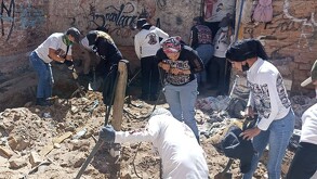 Miembros del colectivo Guerreros Buscadores de Jalisco excavando dentro de un predio con tierra y escombros en el suelo
