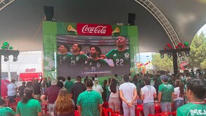 Se observa a mucha gente de pie con playera color verde.