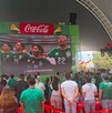 Se observa a mucha gente de pie con playera color verde.