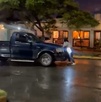 una mujer se aferra a la parte delantera de una camioneta en medio de una calle
