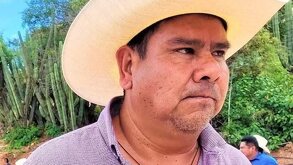 Hombre con expresión seria y un sombrero.