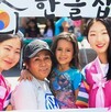Dos mujeres coreanas vistiendo trajes típicos de Corea y sosteniendo un marco para fotos junto con una madre mexicana y su hija durante el KocuFest en Zapopan