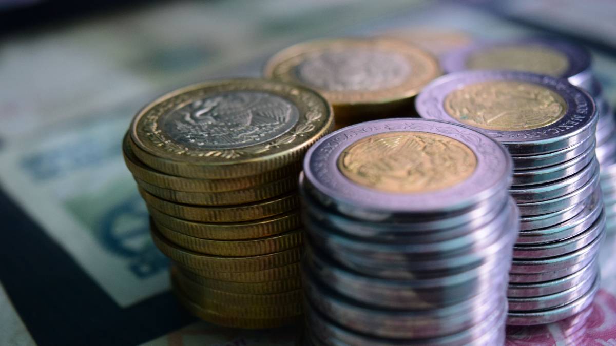 varias pilas de monedas de cinco y 10 pesos mexicanos