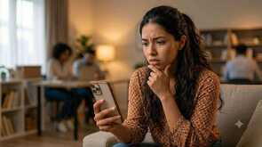 Mujer preocupada revisando su teléfono inteligente al recibir la notificación de almacenamiento lleno en Google Drive y Gmail.