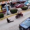 Mujer sentada en el piso con su bebé tras caída de moto