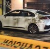 Automóvil Honda color blanco estacionado dentro de un área acordonada con policías de Guadalajara y personas alrededor