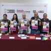 diferentes personas sostienen carteles en la presentación de una feria del empelo para la comunidad lgbt en puebla