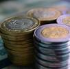 varias pilas de monedas de cinco y 10 pesos mexicanos