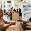 Persona de la tercera edad sentada en una mesa con el personas de credencialización