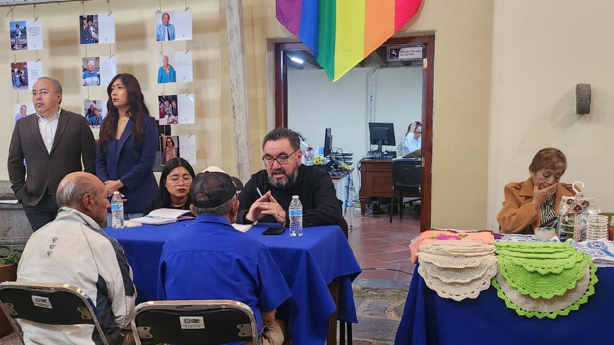 Adultos mayores sentados en una mesa de diálogo para asesoría legal