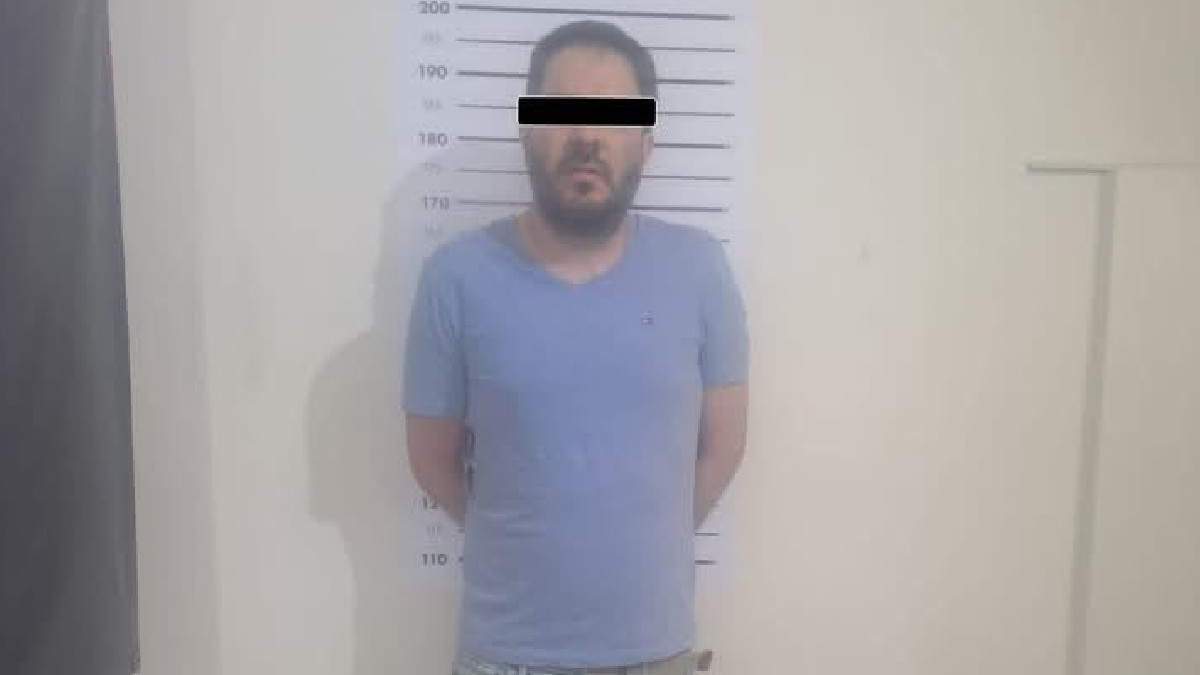 Se observa un hombre con playera azul y con cintilla negra en ojos.
