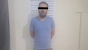 Se observa un hombre con playera azul y con cintilla negra en ojos.