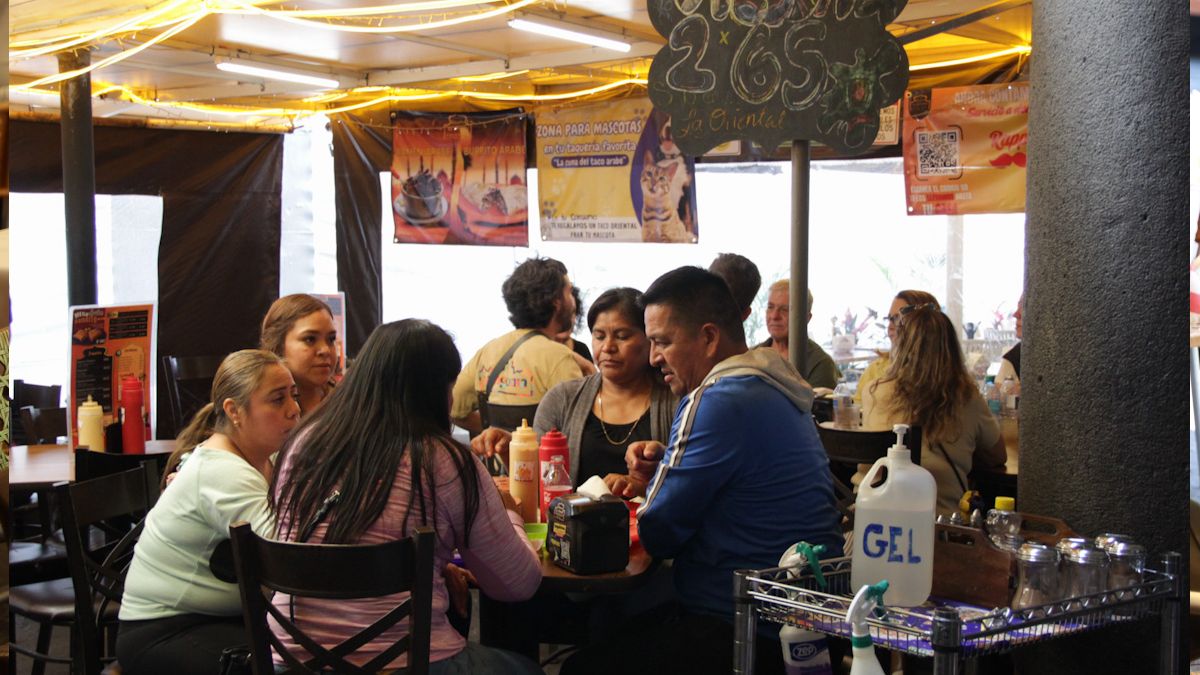 Familia come en la mesa de un restaurante de la capital poblana