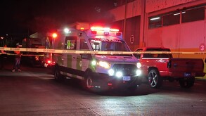 Ambulancia de la Cruz Verde dentro de un área acordonada por la policía en calles de Guadalajara