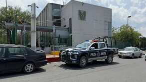 Se observa una fachada color gris de una clínica hospitalaria.