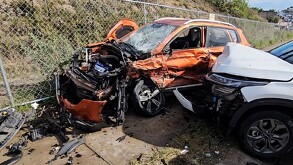 Camioneta Mercedes Benz color naranja completamente destruida del frente tras chocar contra otra camioneta color blanco
