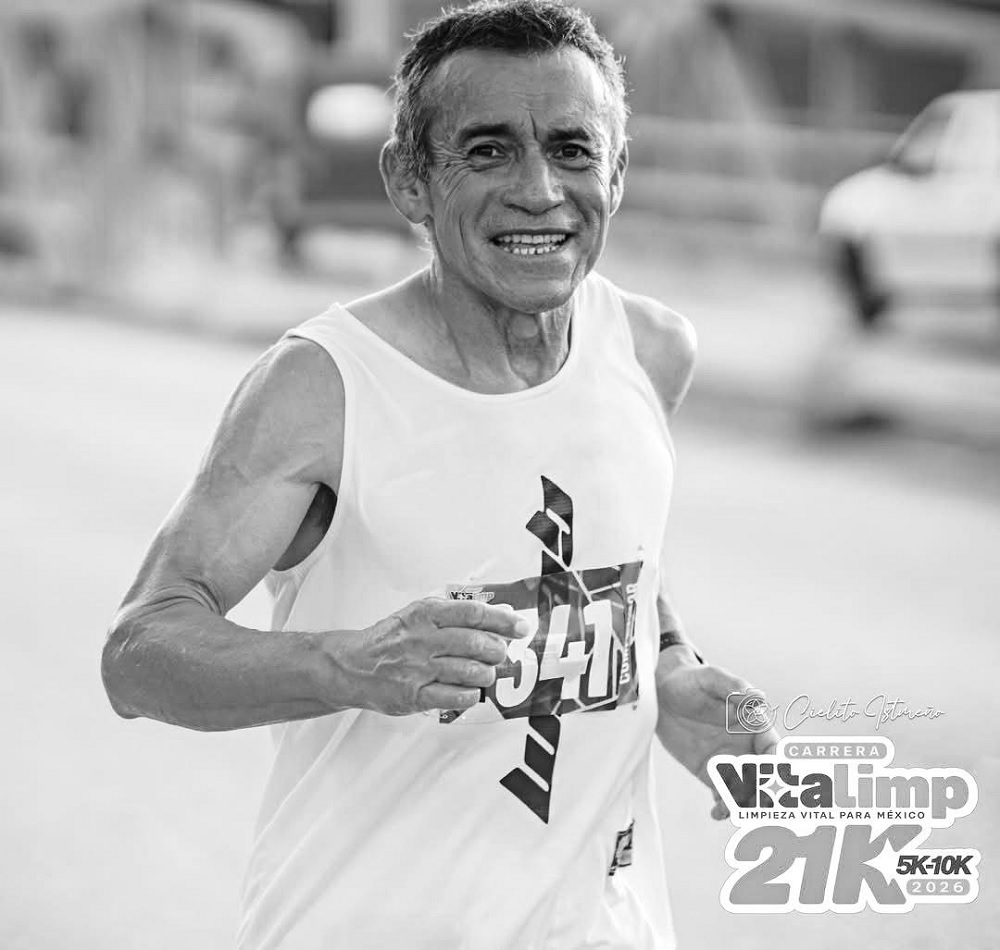 Hombre de la tercera edad corriendo un maratón mientra sonríe.