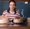 Encargada con pasteles en el mostrador