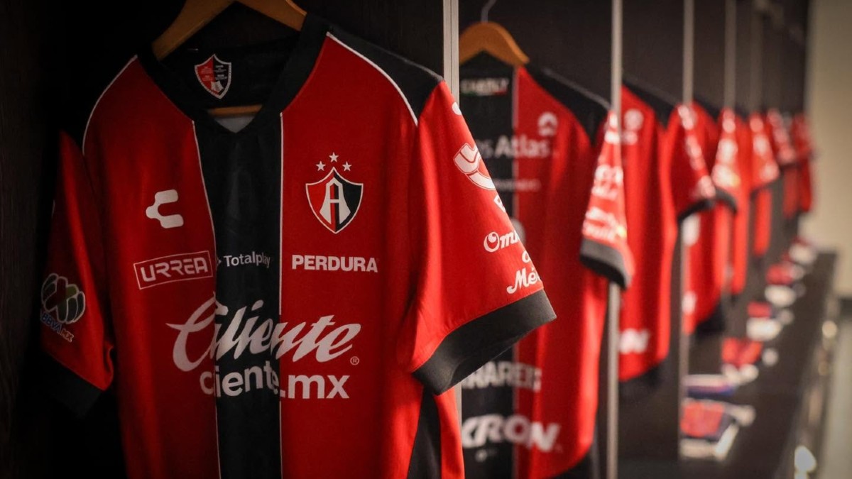 Playeras de los jugadores del Atlas FC colgadas en ganchos dentro de los vestidores del equipo en el Estadio Jalisco