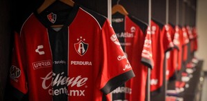 Playeras de los jugadores del Atlas FC colgadas en ganchos dentro de los vestidores del equipo en el Estadio Jalisco