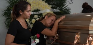 Mujer llorando junto a un féretro por su familiar muerto en Coatzacoalcos, Veracruz.
