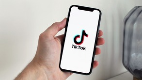 Imagen de una mano sosteniendo un celular con la aplicación TikTok