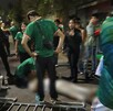 Grupo de personas con la playera de la Selección Mexicana y elementos de la Policía de Guadalajara rodeando a un hombre herido tendido en la calle
